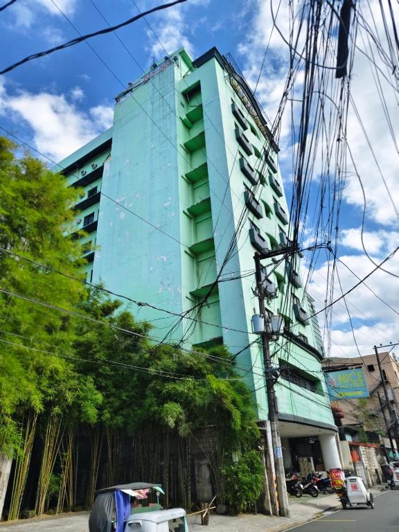 a tall glass building on a city street at Nice Hotel Aurora Cubao in Manila