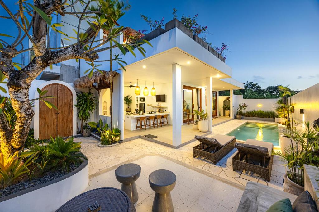 a villa with a swimming pool and a house at Anatha Villa Uluwatu in Badung