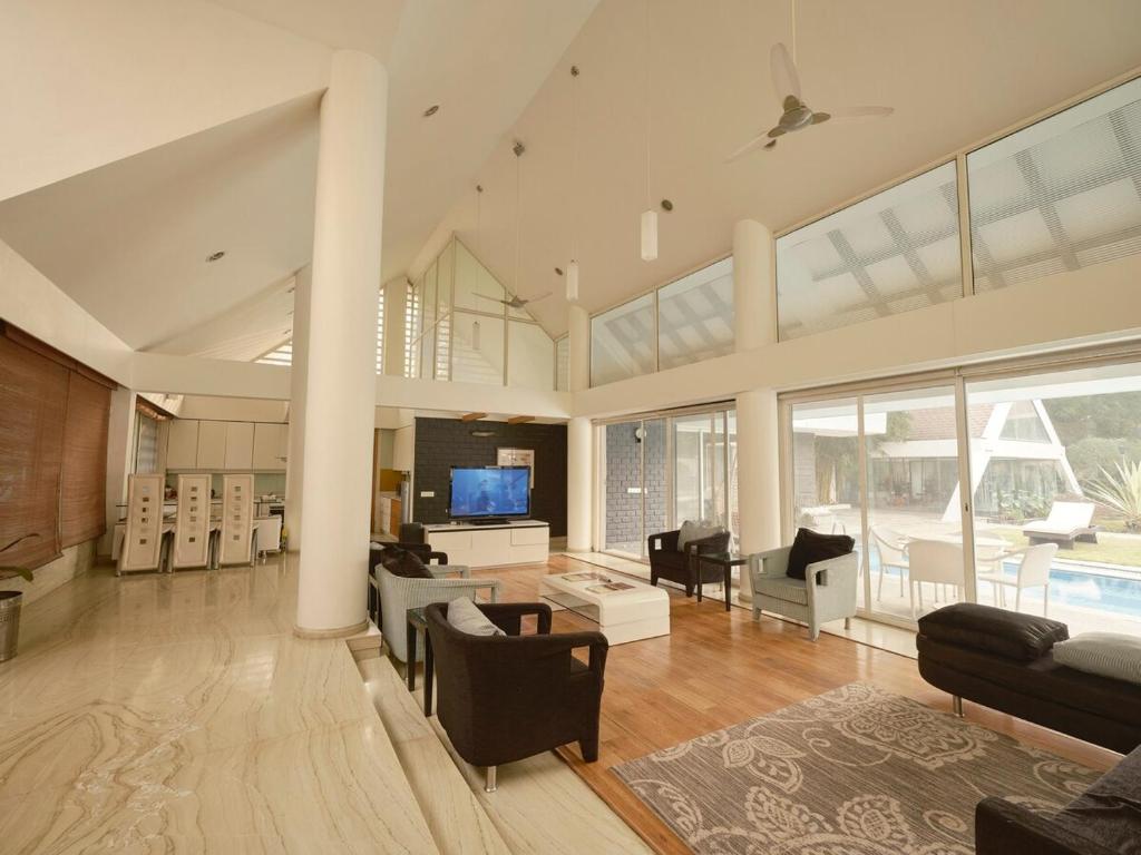 a living room filled with furniture and a tv at RB Villa in Indore