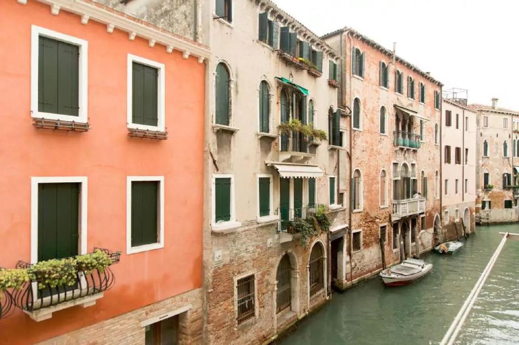 ヴェネツィアにあるドリーミング ベニス アパートメントの水中の船と建物のある運河