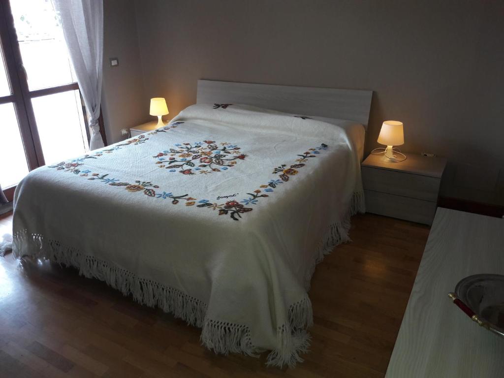 オルヴィエートにあるCasa Robiniaのベッドルーム1室(大型ベッド1台、白い掛け布団付)
