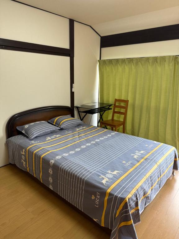 a bedroom with a bed and a table in it at 安易旅館3号房间 in Okayama
