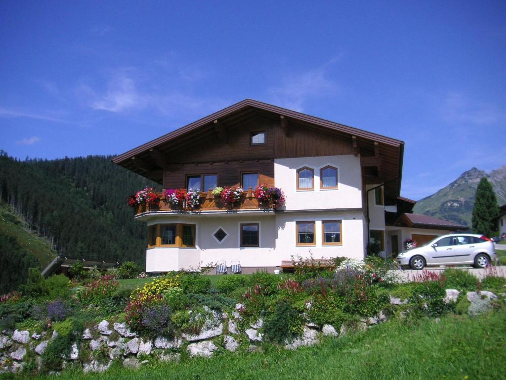 una casa con cajas de flores a un lado. en Aparthaus Birkenheim, en Filzmoos