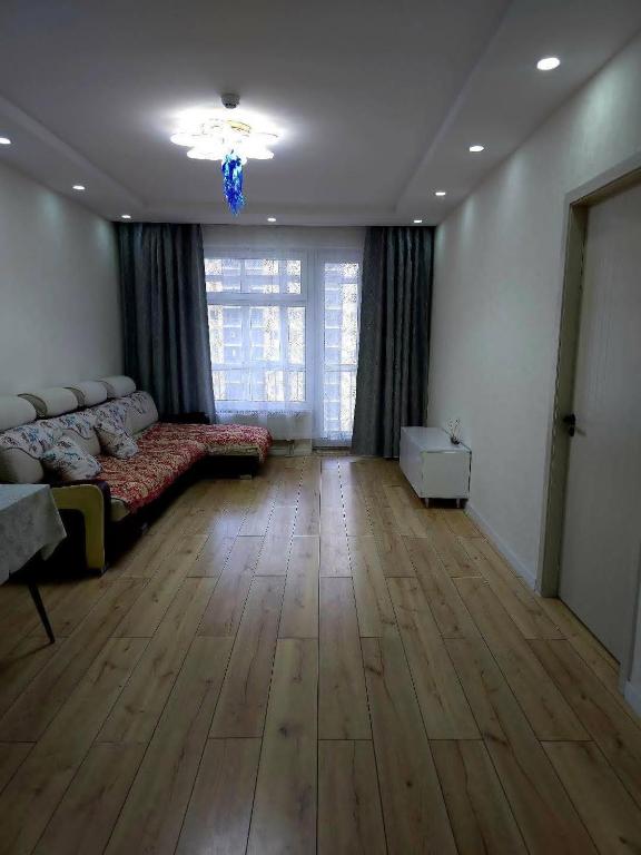 a living room with a couch and a wooden floor at Arga bilig complex in Ulaanbaatar