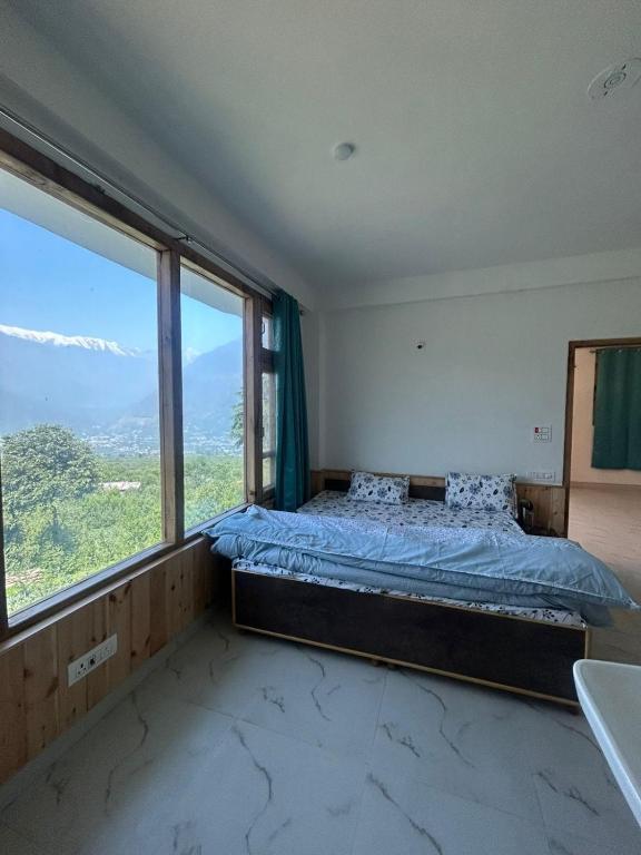 a bedroom with a bed and a large window at Nashala View Homestay in Nagar