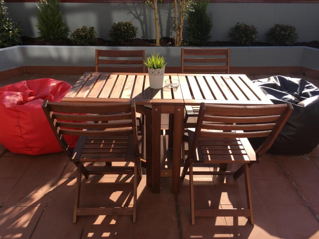 a wooden table and chairs with a potted plant on it at Miguel Bombarda Cozy Apartment in Porto