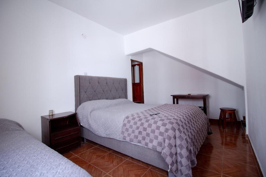 a bedroom with a large bed and a stair case at TIlcara Rooms in Tilcara