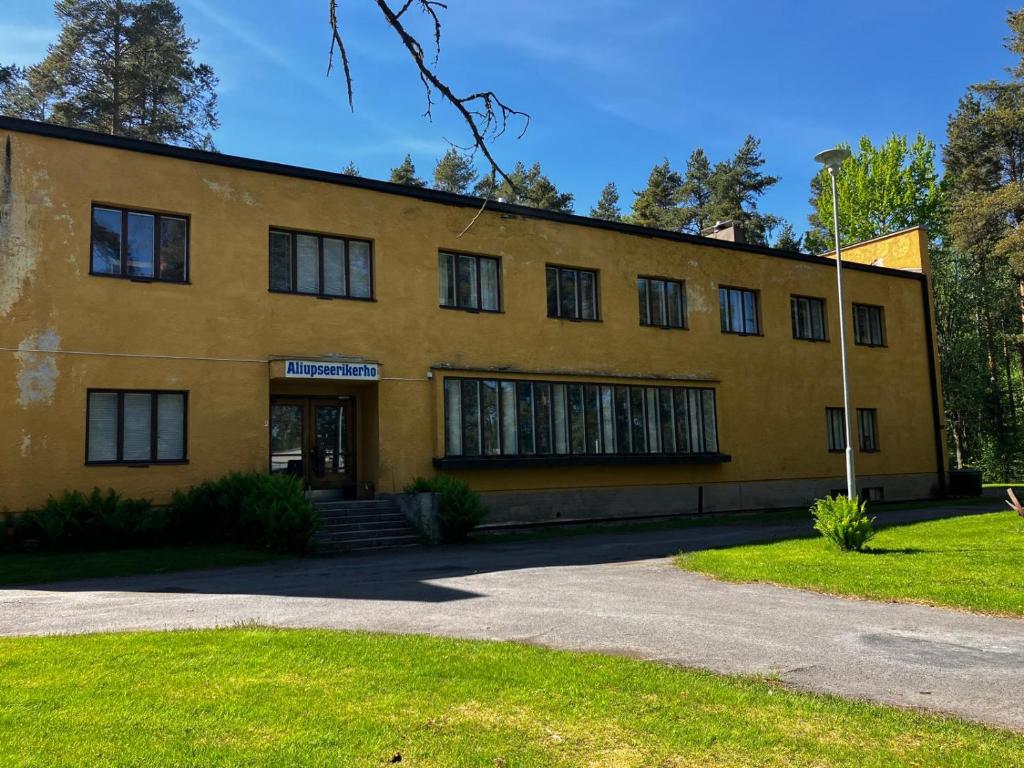 a large yellow building with windows and a driveway at Aliupseerikerho in Kauhava