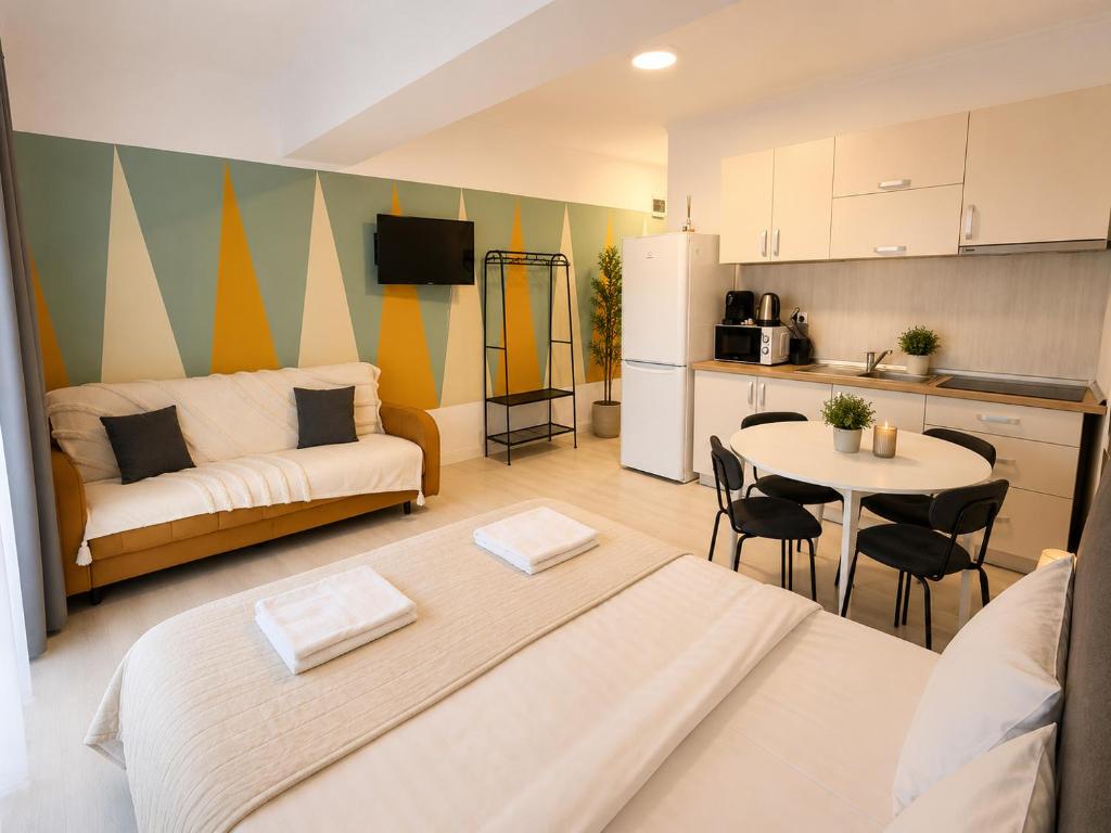 a living room with a couch and a table and a kitchen at DD Apartments - Iuliu Moldovan in Cluj-Napoca