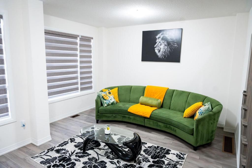 a green couch in a living room with a table at Hiltons Villa in Brampton