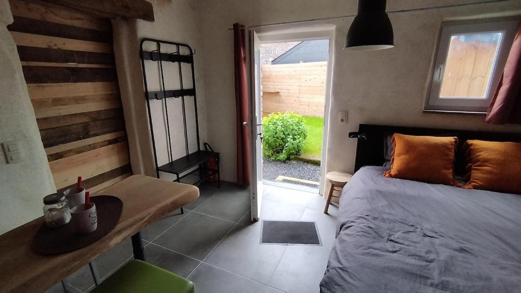 a bedroom with a bed and a door to a yard at La P'tite Brique in Rochefort
