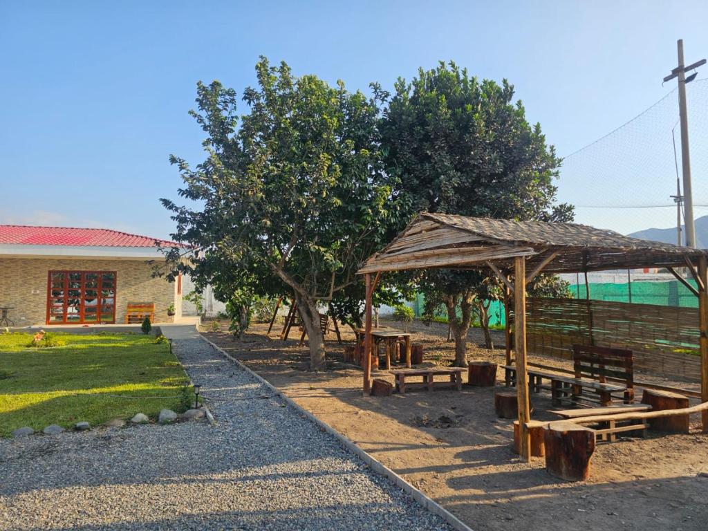 a picnic shelter with benches in front of a building at Casa La Herencia in Huaral
