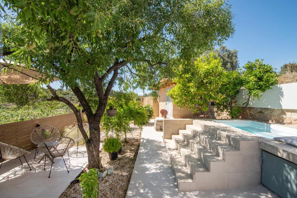 a patio with a tree and a swimming pool at Leonti Maison in Egina