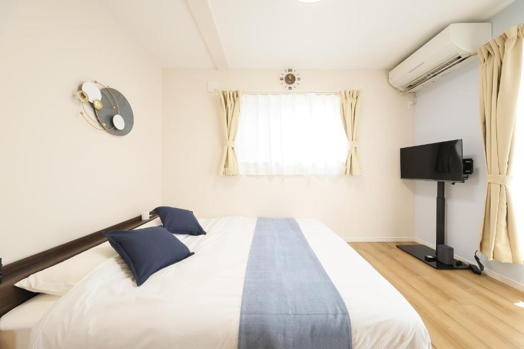 a bedroom with a bed and a flat screen tv at 天空山 in Kawagoe