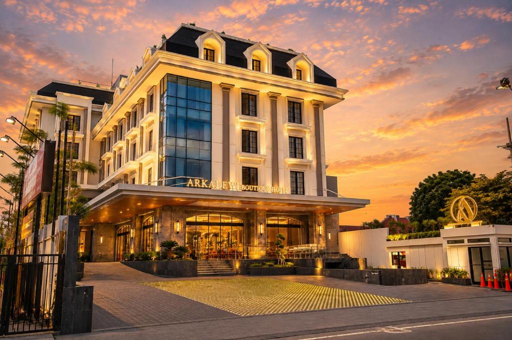 a large white building with a sunset in the background at Arkadewi Boutique Hotel Prawirotaman in Yogyakarta
