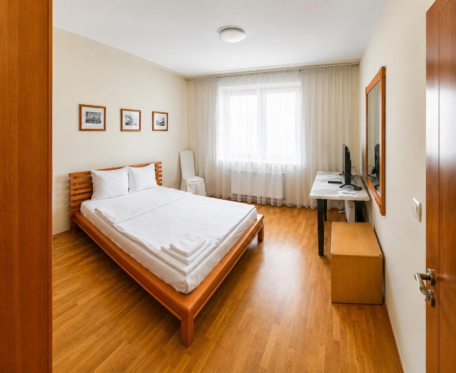a bedroom with a bed and a desk and a television at Mesta Room in Gotse Delchev