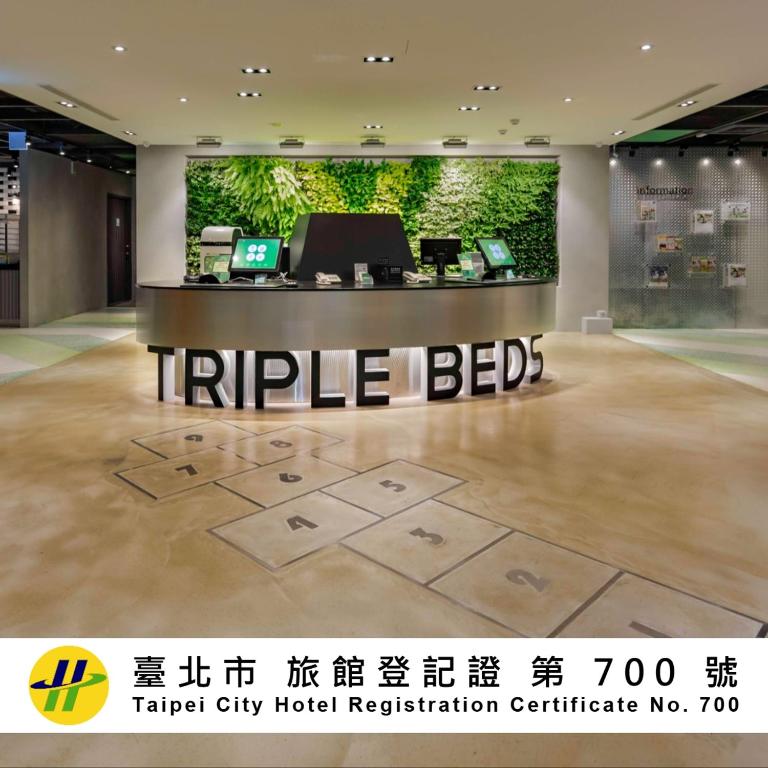 Eine Hotellobby mit einem „Triile Beds“-Schild auf dem Boden. in der Unterkunft Green World Triple Beds in Taipeh