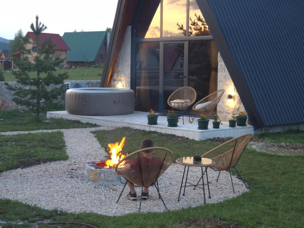 a group of chairs sitting around a fire in a yard at Villa Silence in Žabljak