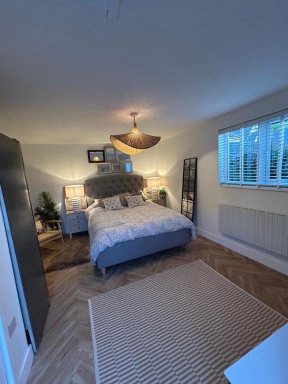 a bedroom with a bed and a chandelier at kingsize Little Home in Stamford