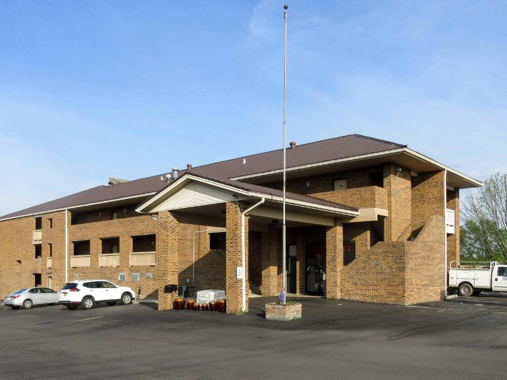 a brick building with cars parked in a parking lot at Quality Inn Harrodsburg in Harrodsburg
