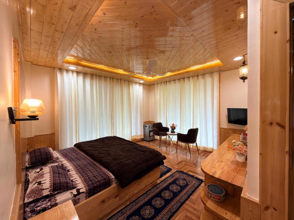 a bedroom with a large bed and a table at Oak & Amber Retreat in Manāli