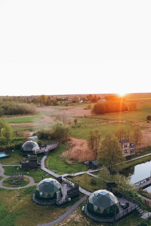 an aerial view of a field with tents and a river at Kopuła glampingowa Loft in Krzesimów