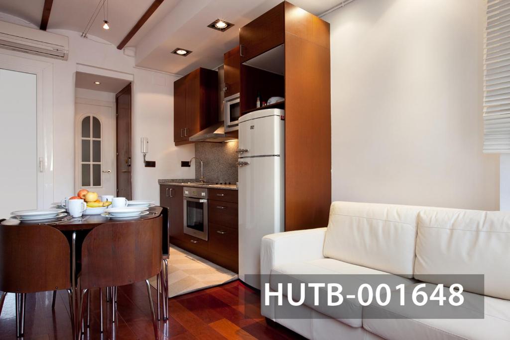 Ghat Apartment Poble Sec Barcelona في برشلونة: مطبخ مع طاولة وثلاجة بيضاء