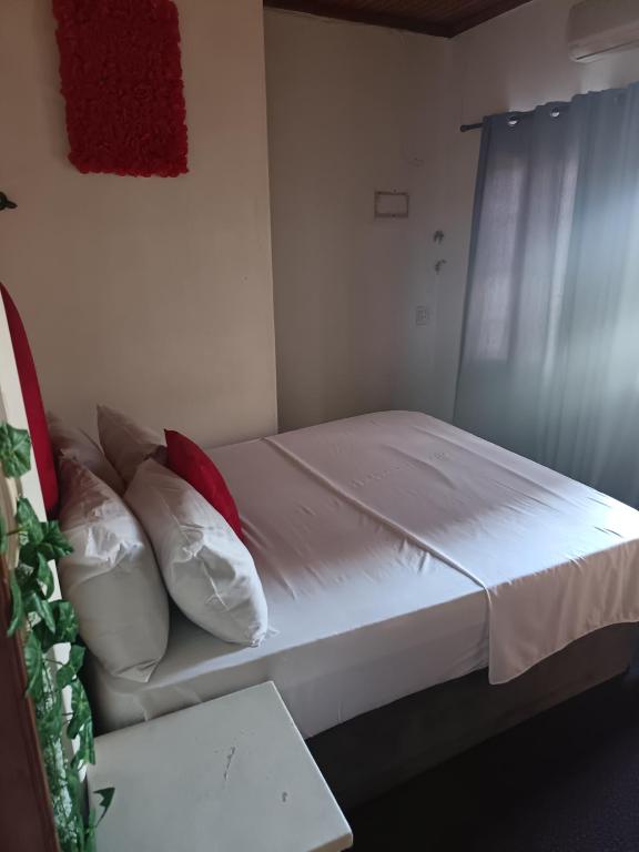 a bedroom with a bed with white sheets and pillows at Fourways guesthouse & spa in Fourways
