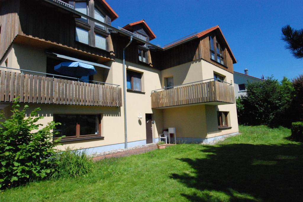 an apartment building with a balcony and a yard at Ferienwohnungen Fliegerstrasse in Gersfeld