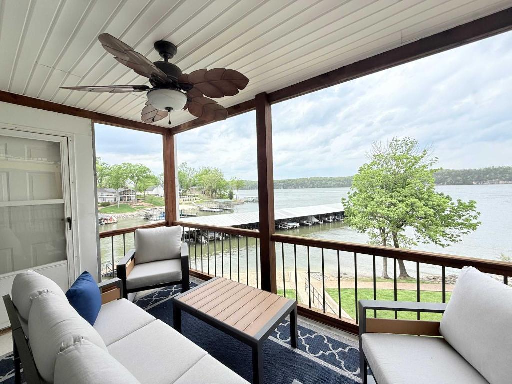 a screened in porch with a view of the water at Lakefront Vibes Waterfront Pool in Osage Beach