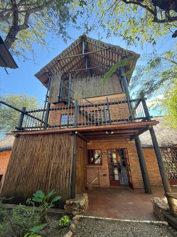 a house with a balcony on top of it at Bush and Gables in Marloth Park