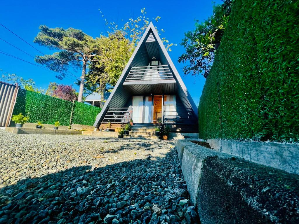 a small house with a thatched roof and a gravel yard at Rakushki's House 2 in Tsikhisdziri in Kobuleti