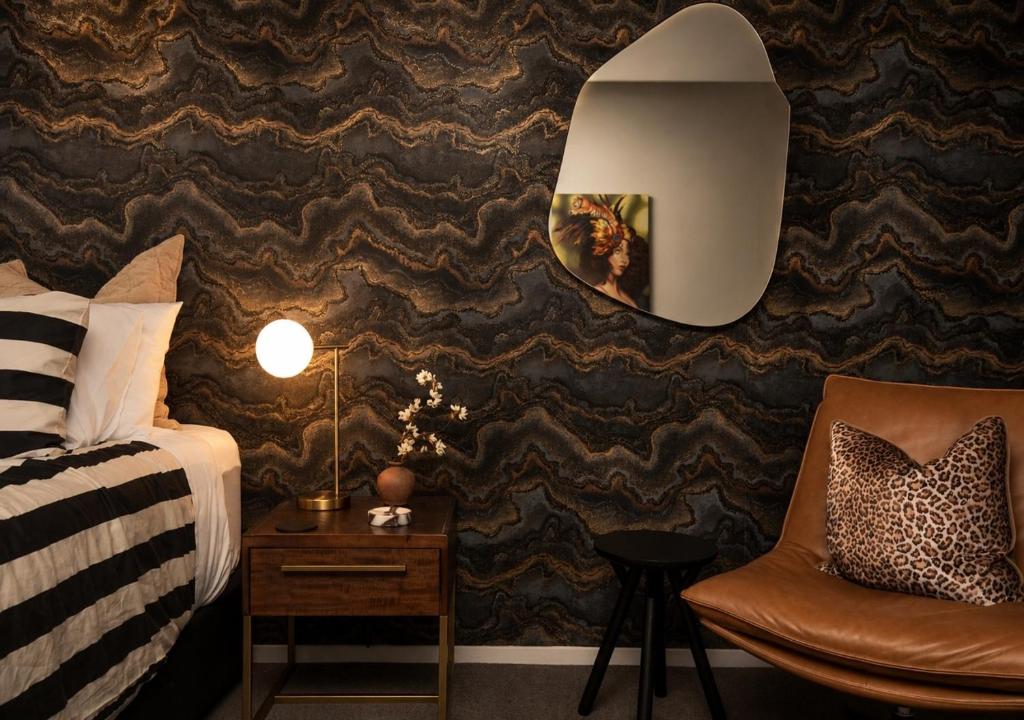 a hotel room with a bed and a chair at Cathedral Junction Apartments in Christchurch