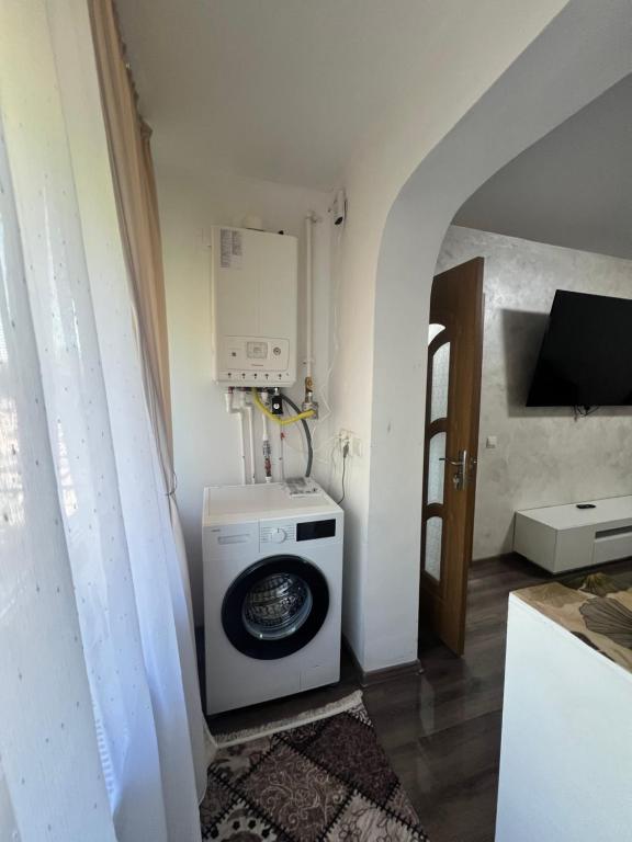 a washer and dryer in a room with a door at Apartamente Giu in Giurgiu