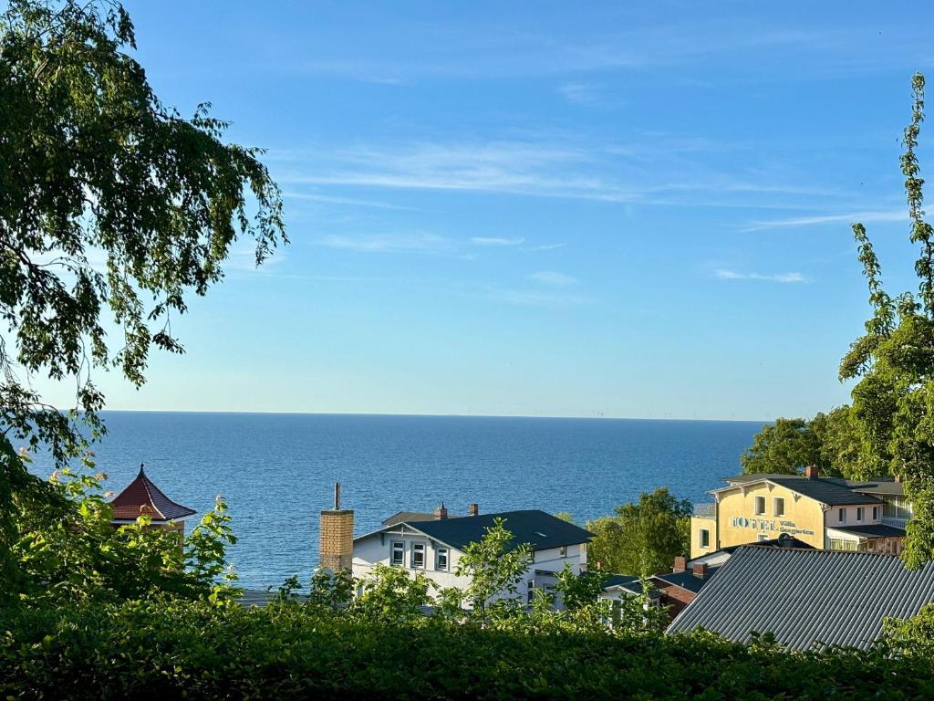 a view of the ocean from a town with houses at Ruhe-Natur-Meerblick-Das-Atelier-in-Lohme-Wandern-Radfahren-Golf-direkt-vor-der-Tuer in Lohme