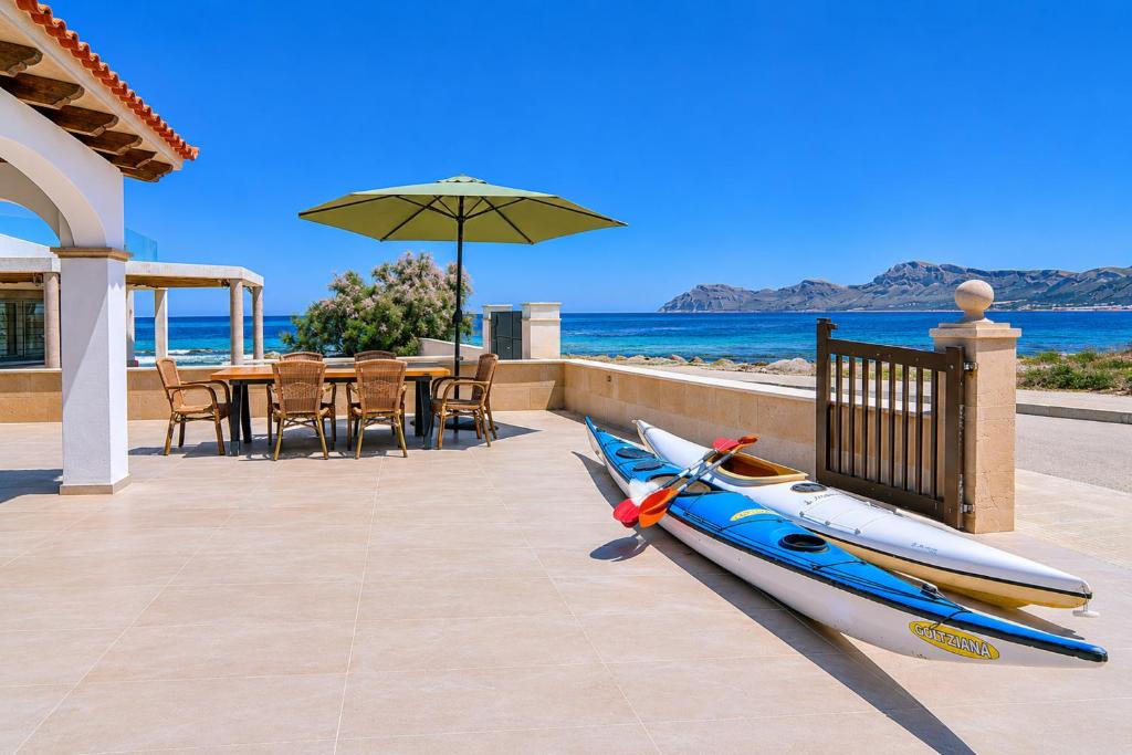 a boat sitting on a patio next to a table with an umbrella at 045 Casa Embat ETV10796 by Mallorca Charme in Son Serra de Marina