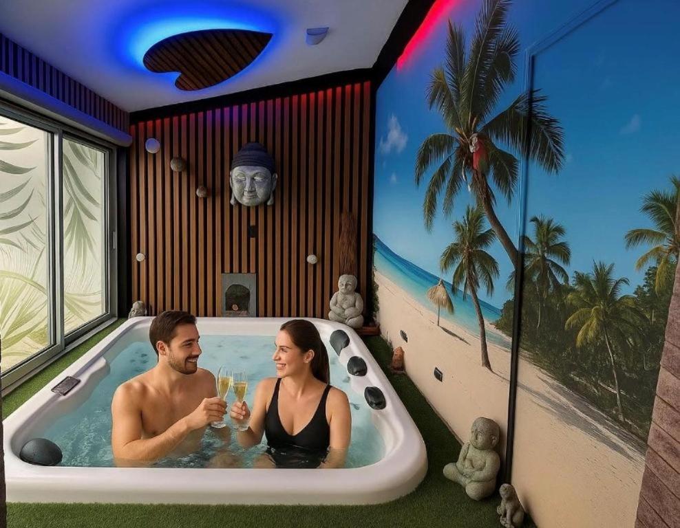 a man and woman sitting in a bath tub with drinks at Le Miroir in Domérat