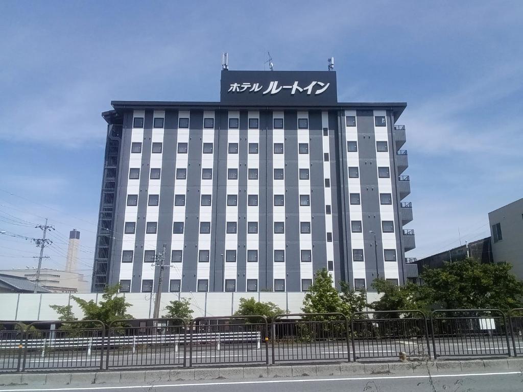 a large building with a sign on top of it at Hotel Route-Inn Ogaki Inter in Ogaki