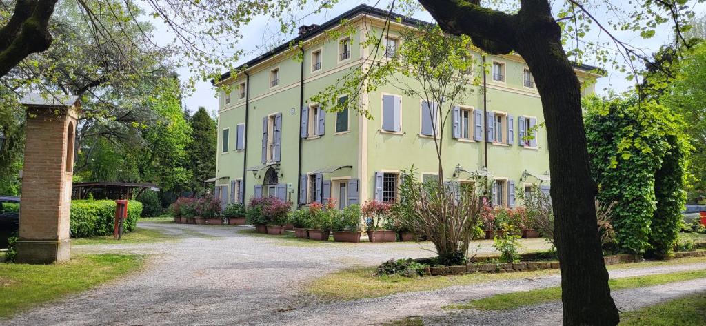 a large yellow building with windows and plants at Residence Villa Stufler in Modena