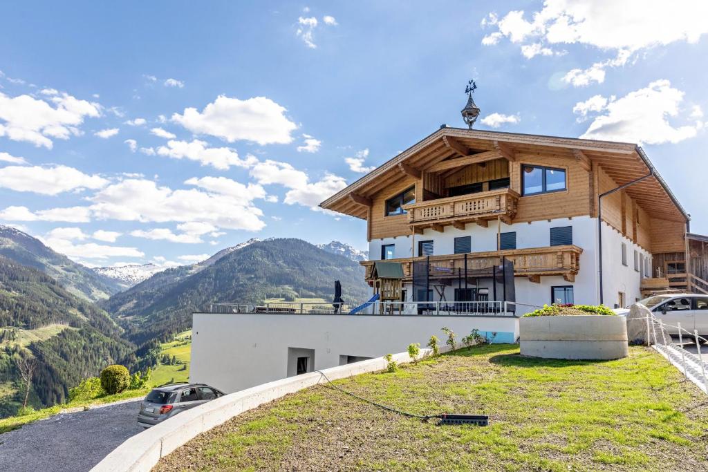 a house on a hill with a view of mountains at Ferienwohnung Grubgut in Taxenbach