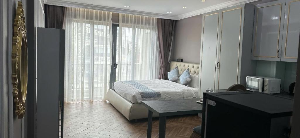 a bedroom with a bed and a desk and a window at Khách Sạn PG Boutique in Vung Tau