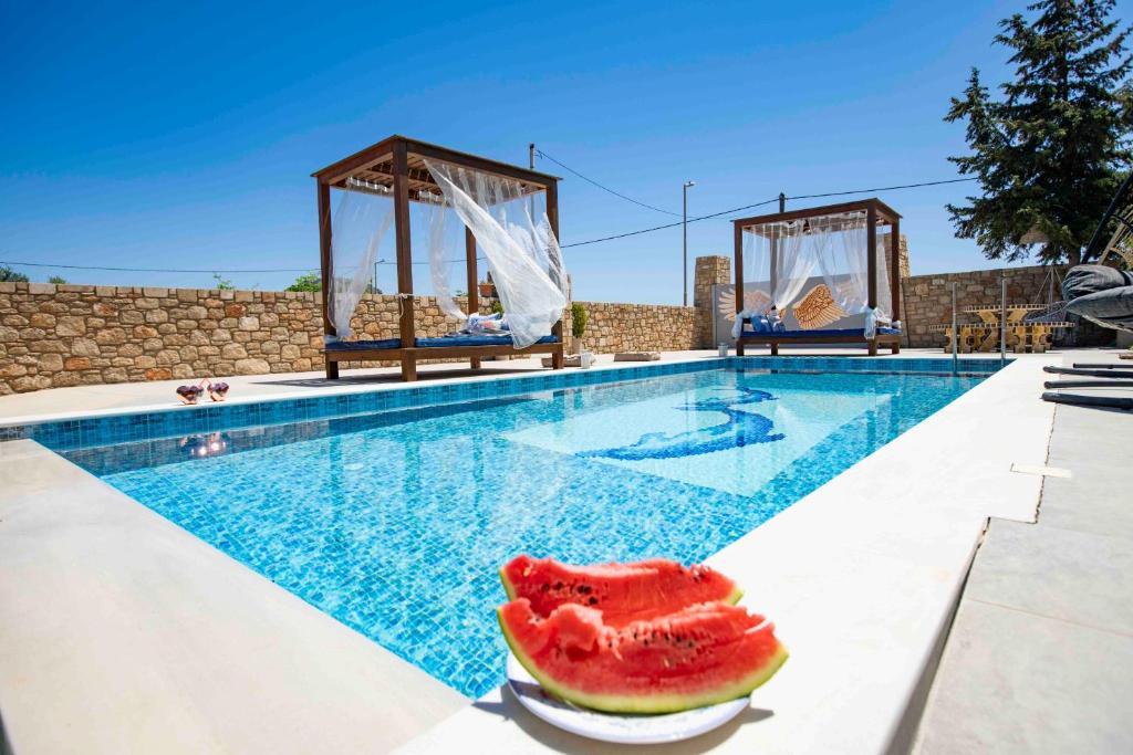 a pool with a slice of watermelon on the edge at Traounou Serenity Villa Near to Afandou Beach in Afantou