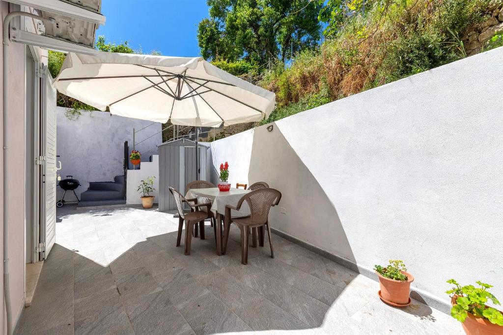 a table and chairs with an umbrella on a patio at Villa Angela in Nulvi