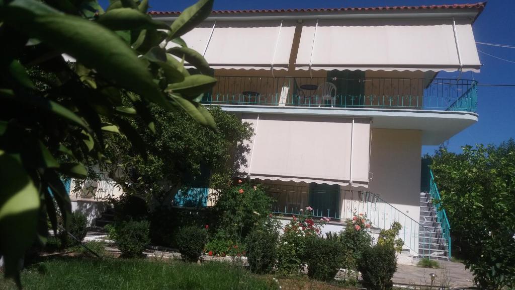 a white building with a balcony and some plants at Mouragio Apartments in Tiros