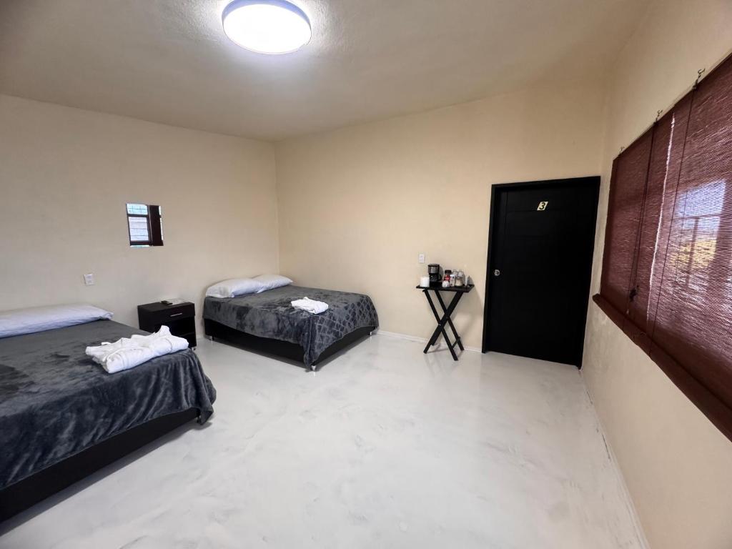 ein Zimmer mit zwei Betten und einem Tisch darin in der Unterkunft Casa Avus in Tetelco