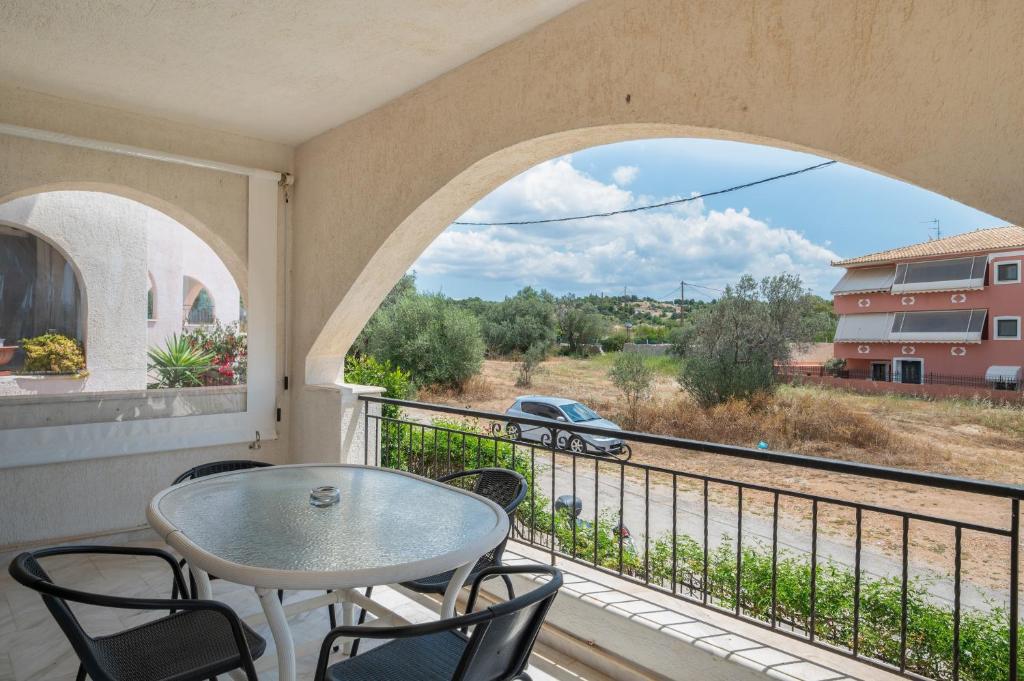 a balcony with a table and chairs and a view at Kyma Arch House in Porto Heli