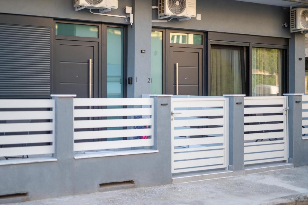 a white fence in front of a house at DNS Elements Apartments 1 in Nea Karvali