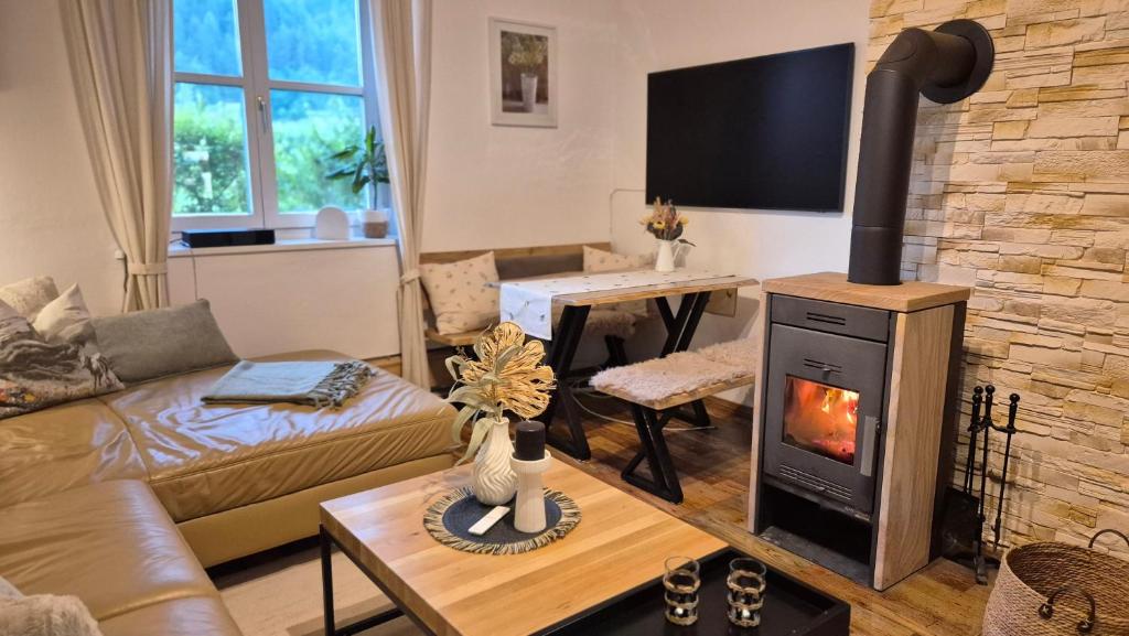a living room with a fireplace and a couch at Auszeitplatzl in Unken