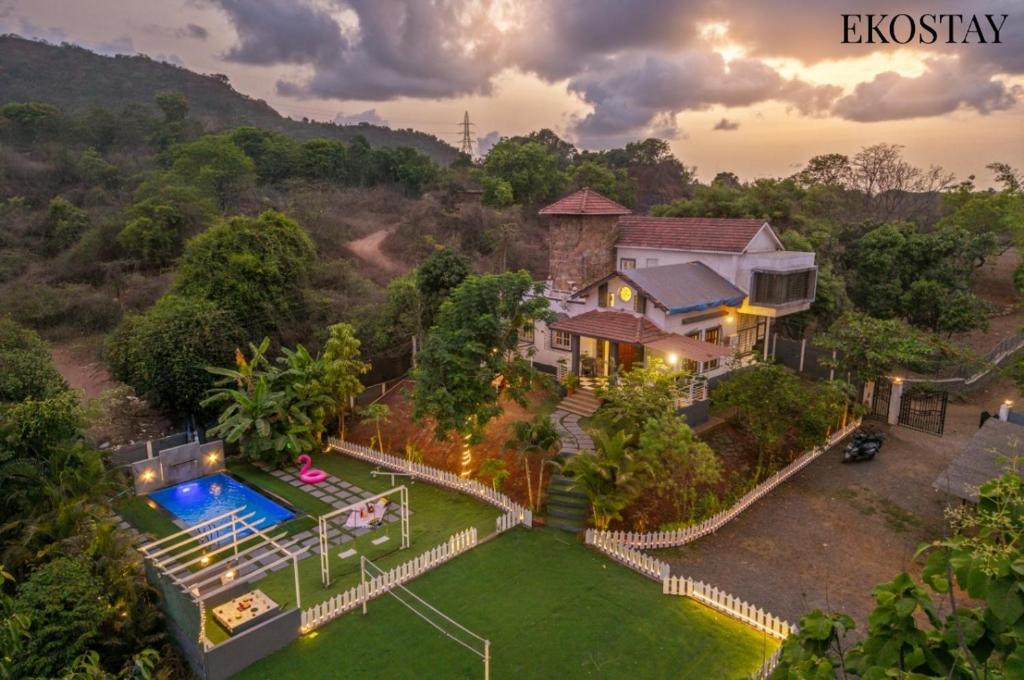 an aerial view of a house with a swimming pool at EKOSTAY - Mount Emerald Villa in Alibaug