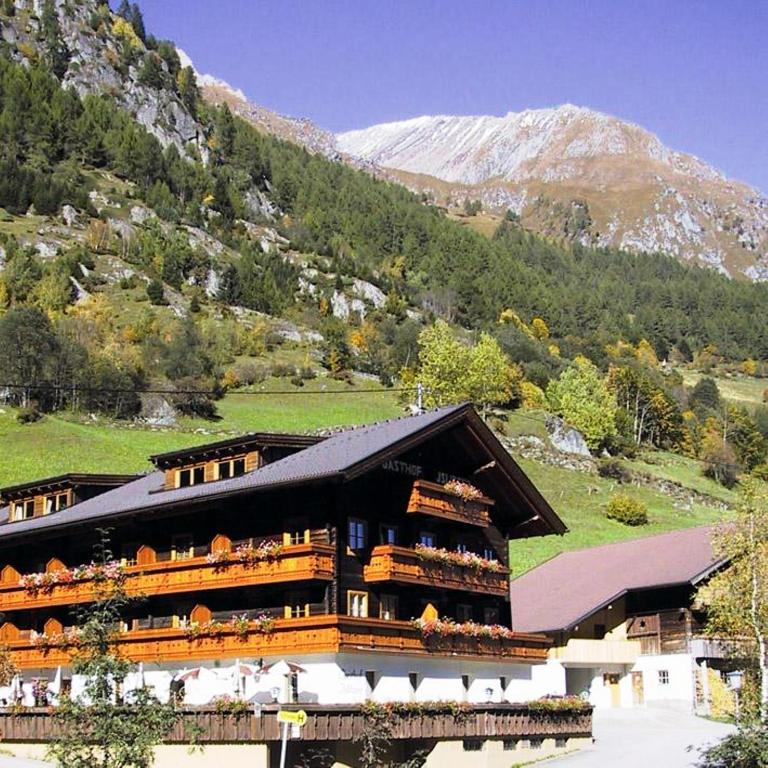a large building with a mountain in the background at Hotel Gasthof Islitzer in Prägraten